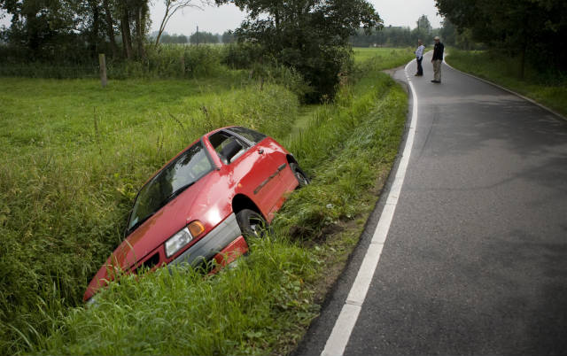 Red car lying in a ditch