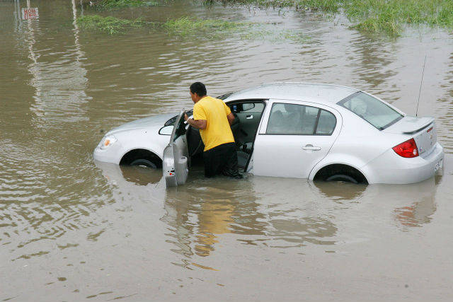 Man pushing car in flood