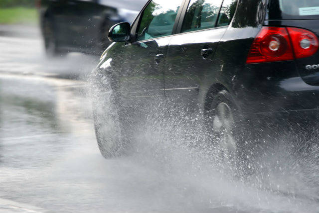 black car driving through rain