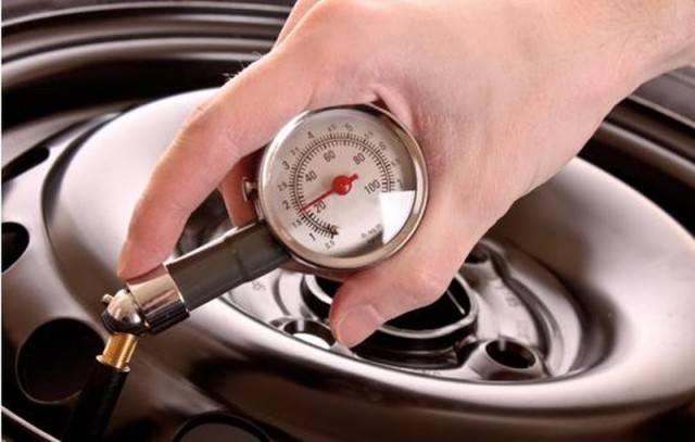 Using tire pressure gauge to check tire pressure