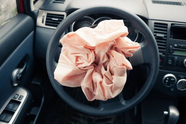 An airbag that's deploying on a steering wheel