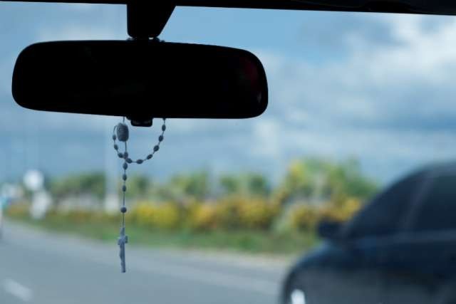 Rosary coiled on a rear view mirror