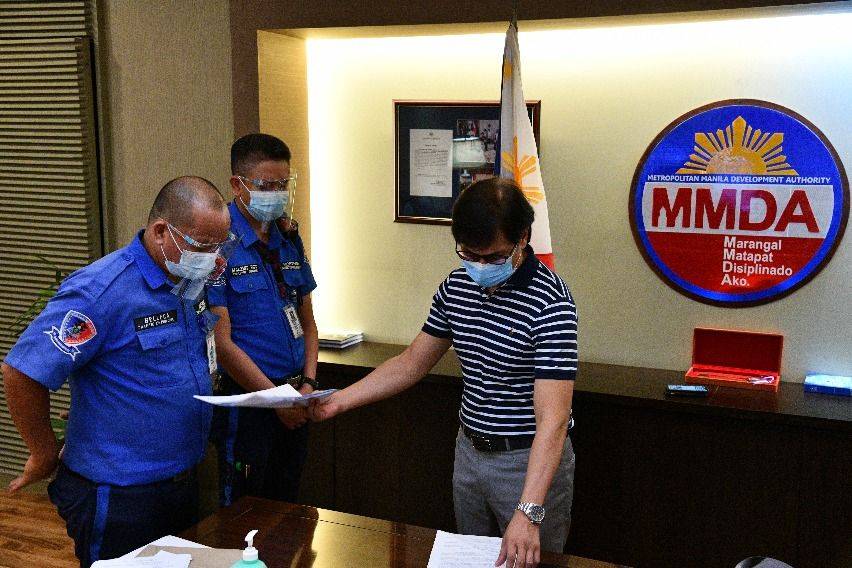 MMDA Chairman Benhur Abalos serves respective notices to the two traffic enforcers being investigated